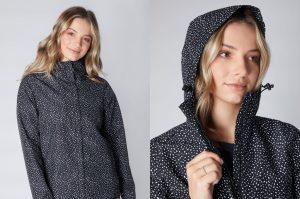 Woman wears zipped up black jacket rain with white spots