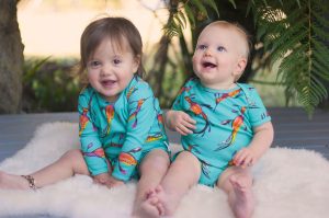 Two babies laughing in the sand